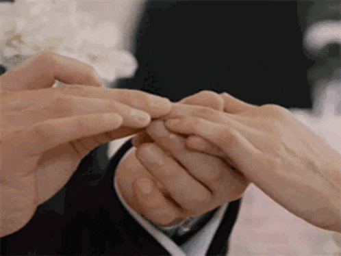 a man putting a ring on a woman 's finger