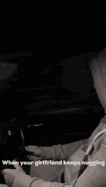 a man in a hooded jacket is driving a car with the caption " when your girlfriend keeps nagging "