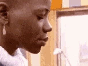 a close up of a person 's face with a towel around their neck and a window in the background .