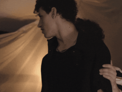a man with curly hair is being held by a woman in a black shirt
