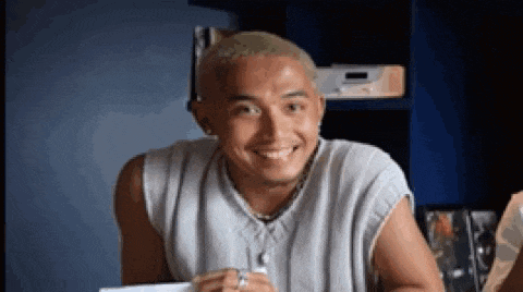 a man is smiling while sitting at a table in front of a radio .