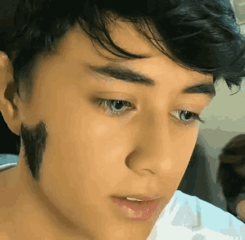 a close up of a young man 's face with a black stripe on his face
