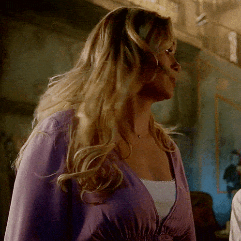 a woman in a purple top is looking down