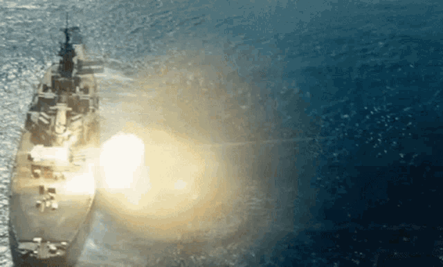 a large ship is floating in the ocean with the sun shining through the water