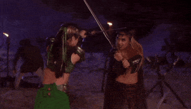 a woman in a green dress is holding a sword in front of a green fire .