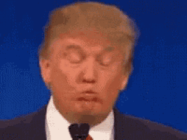 donald trump is making a funny face while giving a speech .