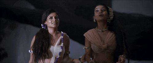 two women standing next to each other and smiling