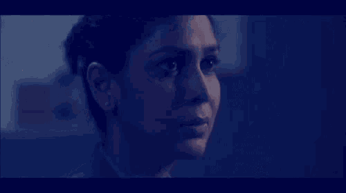 a close up of a woman 's face with a dark blue background