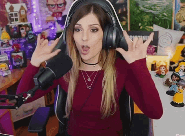 a woman wearing headphones is making a devil horns gesture