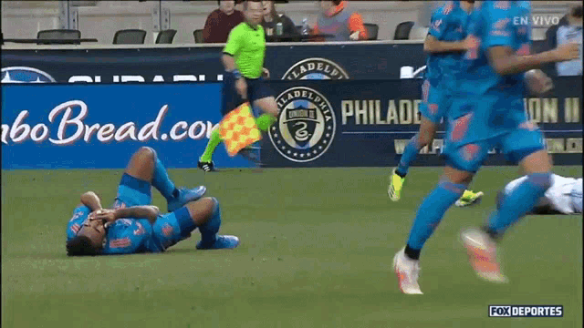 a soccer game is being played in front of a banner that says philadelphia