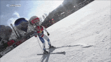 a person skiing down a snowy slope with a sign that says audi