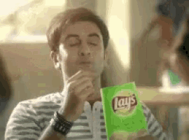 a man is eating a bag of lays potato chips .