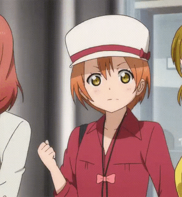 a girl wearing a red shirt and a white hat with a red ribbon