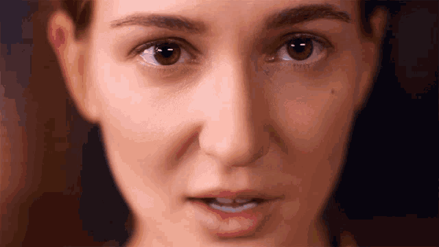 a close up of a woman 's face with a serious look on her face