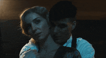 a man is smoking a cigarette while a woman holds his neck
