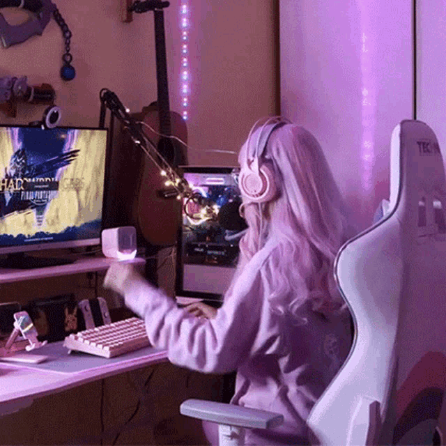 a woman wearing headphones is playing a video game on a computer .