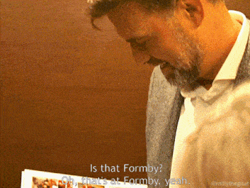 a man with a beard is looking down at something and says is that formby oh that 's at formby yeah