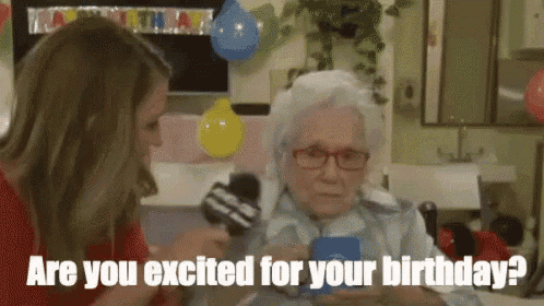 a woman is talking to an elderly woman who is holding a card and asking her if she is excited for her birthday .