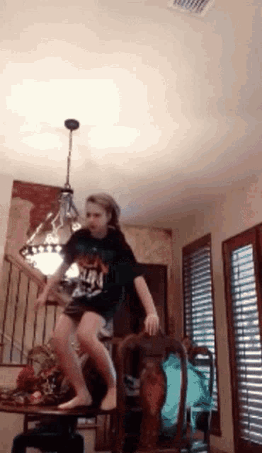 a girl in a metallica shirt jumps in the air