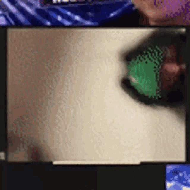 a blurred image of a person 's face with a green object in the foreground