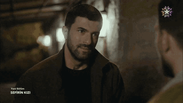 a man with a beard is talking to another man in a tv show