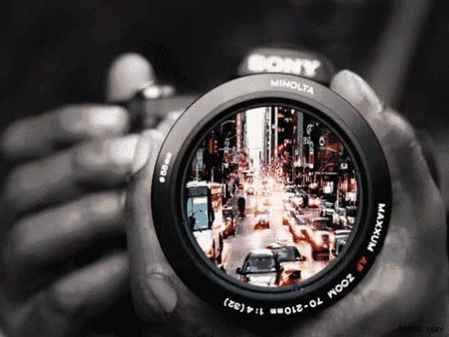 a person holding a sony minolta camera in their hands