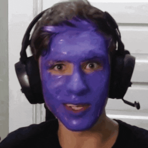 a man wearing headphones and a purple face mask