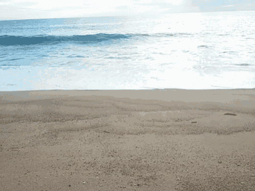 a beach with waves crashing on the shore