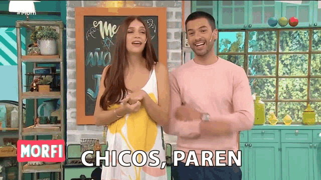 a man and a woman are standing next to each other in front of a chalkboard that says " the ano "