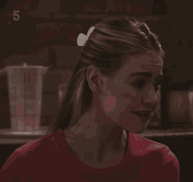 a woman in a red shirt has the number 5 on the bottom right