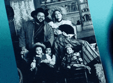 a black and white photo of a family dressed in cowboy costumes