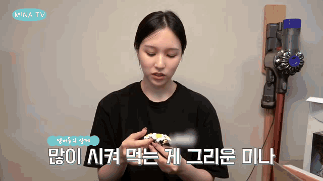 a woman holding a cupcake with mina tv written on the bottom