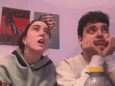 a man and a woman are sitting next to each other with their hands on their chins .