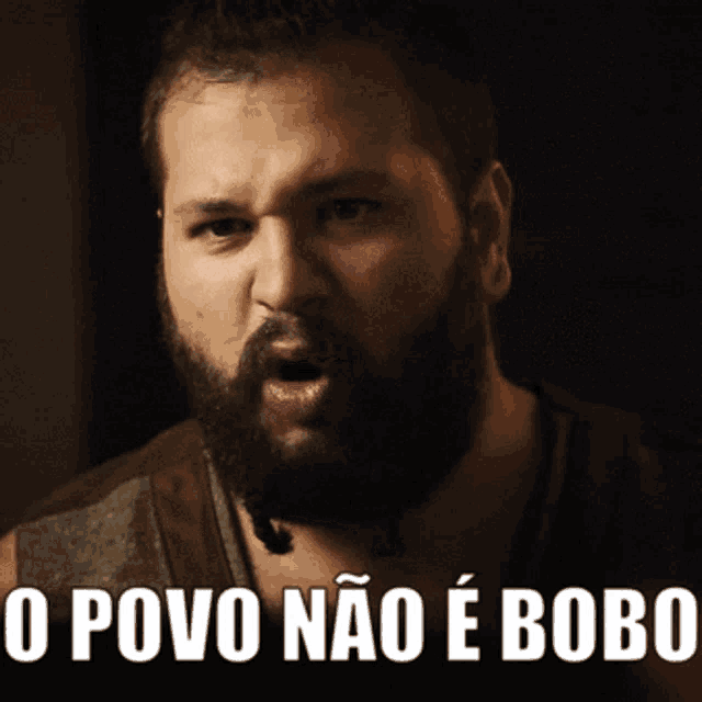 a man with a beard has the words o povo nao e bobo written below him