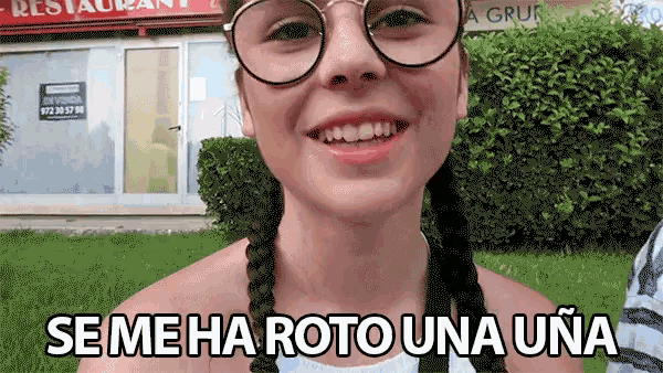 a girl wearing glasses is smiling and says se me ha roto una uña