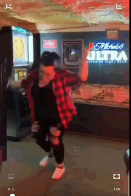 a person is dancing in front of a sign that says ' michelob ultra '