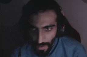 a man with a beard is wearing headphones and looking at the camera .