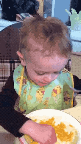a baby wearing a bib with winnie pooh on it