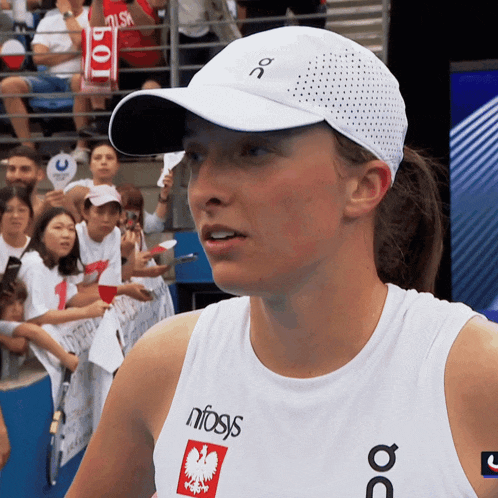 a woman wearing a white hat and a white tank top that says nfasis