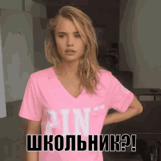 a woman wearing a pink shirt that says pin