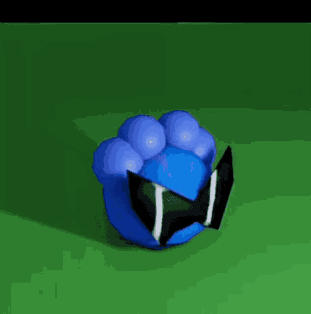 a blue ball with a black and white bow tie on it is sitting on a green surface .