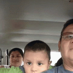 a man is holding a baby in his arms while a woman looks on