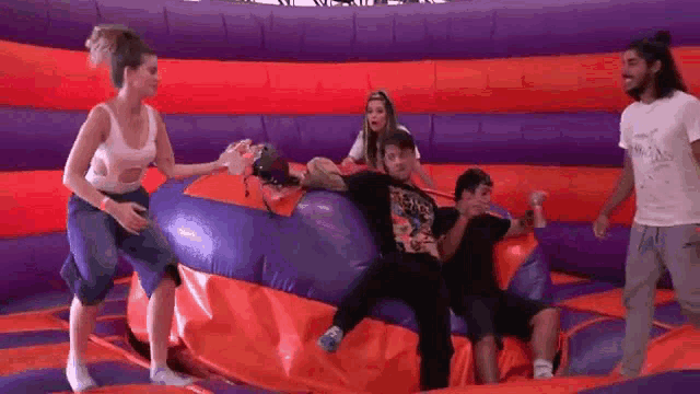 a group of people are playing on a bouncy castle .