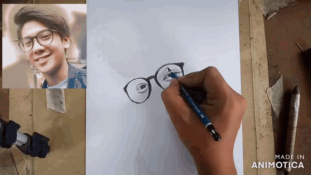 a person is drawing a picture of a boy wearing glasses with a pencil