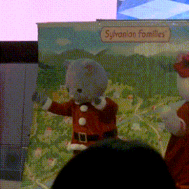 a sylvanian families sign with a stuffed animal in a santa outfit