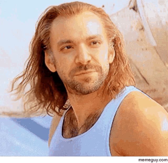 a man with long hair and a beard is wearing a tank top