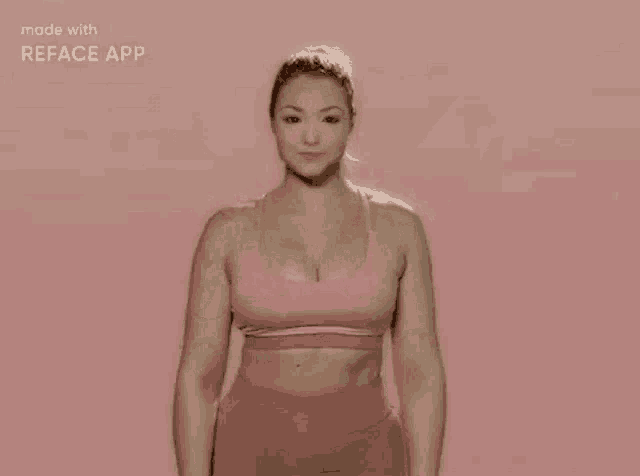 a woman in a pink sports bra and pink shorts is making a funny face with her hands .