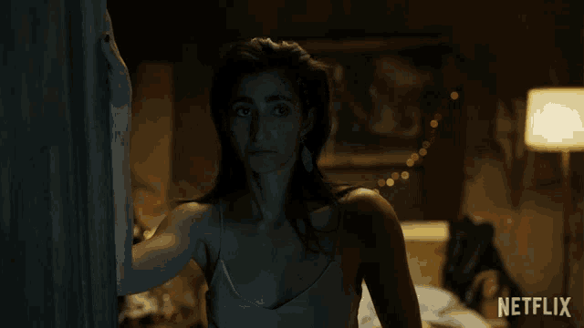 a woman standing in a dark room with vale written on the bottom of her chest