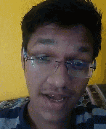 a man wearing glasses and a striped shirt smiles for the camera