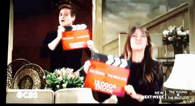 a man and a woman are holding a clapper board that says the young restless